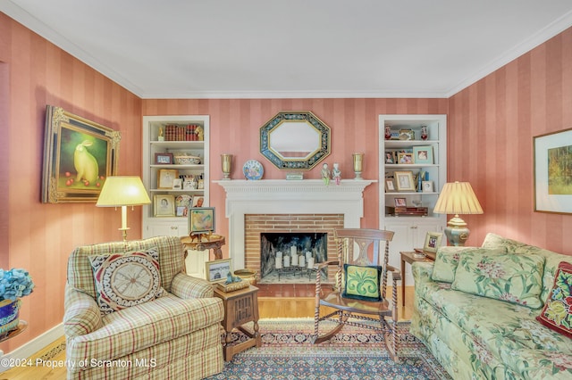 living room featuring built in shelves, crown molding, and a brick fireplace