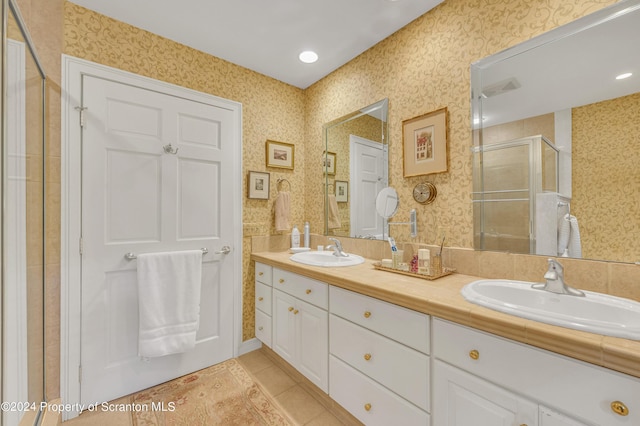 bathroom featuring tile patterned flooring, vanity, and a shower with door