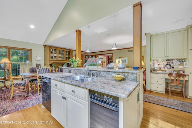 kitchen featuring a center island, sink, light stone counters, light hardwood / wood-style flooring, and vaulted ceiling