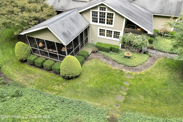 rear view of property with a sunroom and a yard