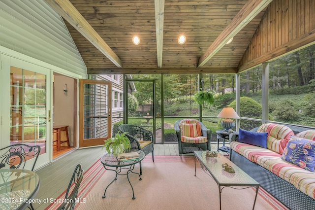 sunroom / solarium featuring lofted ceiling with beams and wooden ceiling