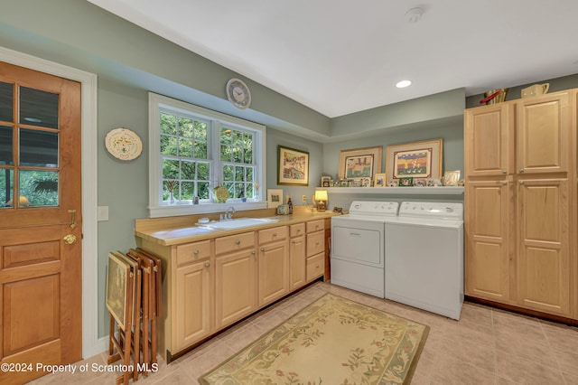 laundry area featuring cabinets, washing machine and dryer, light tile patterned floors, and sink