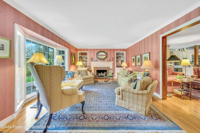 living room featuring crown molding, a fireplace, a healthy amount of sunlight, and wood-type flooring