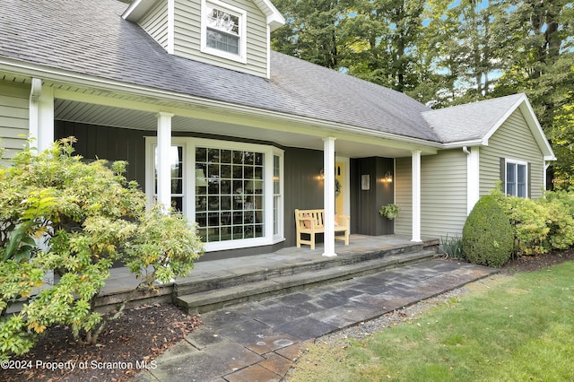 view of exterior entry featuring covered porch