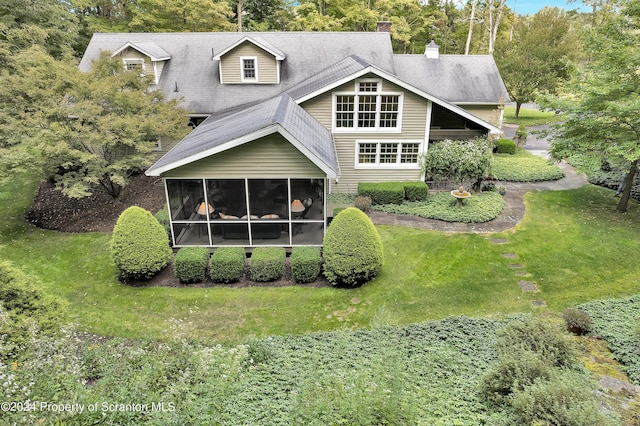 back of property featuring a lawn and a sunroom