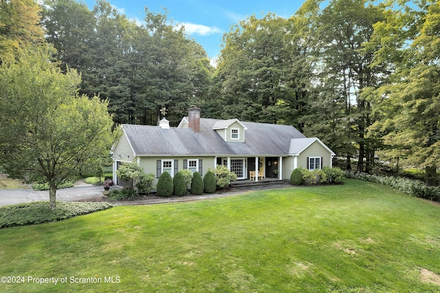 new england style home featuring a porch and a front lawn