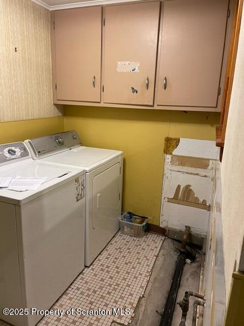 laundry area featuring light tile patterned floors, cabinet space, and washing machine and clothes dryer