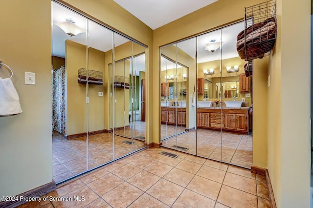 bathroom with tile patterned flooring, vanity, and an inviting chandelier