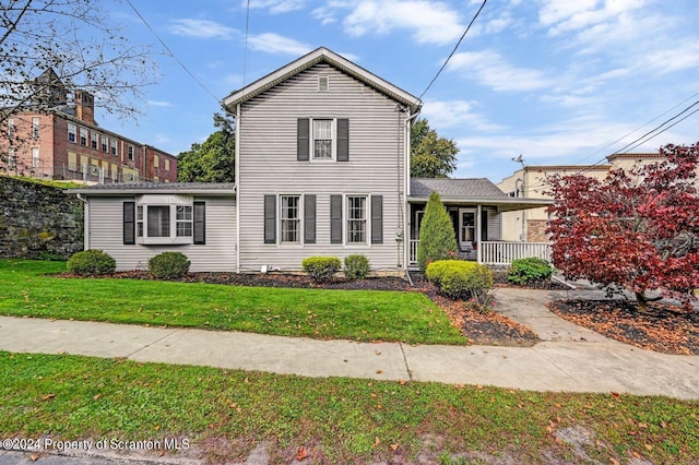 view of front facade featuring covered porch and a front yard