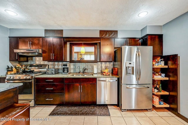 kitchen featuring light stone counters, sink, stainless steel appliances, and tasteful backsplash