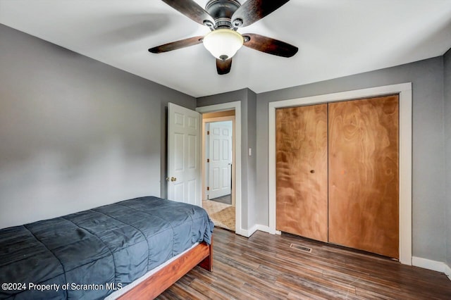 bedroom with ceiling fan, dark hardwood / wood-style floors, and a closet