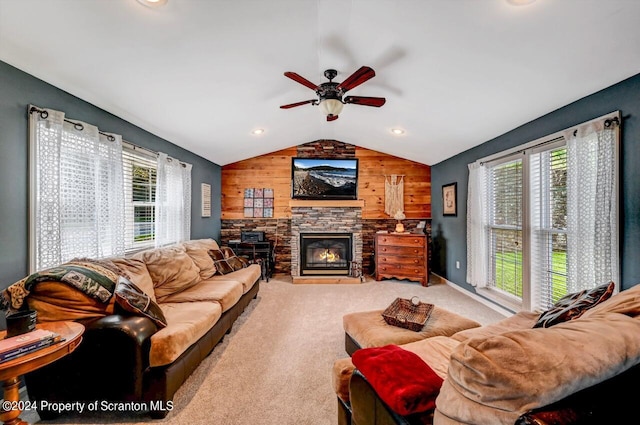 living room with a fireplace, ceiling fan, plenty of natural light, and wood walls