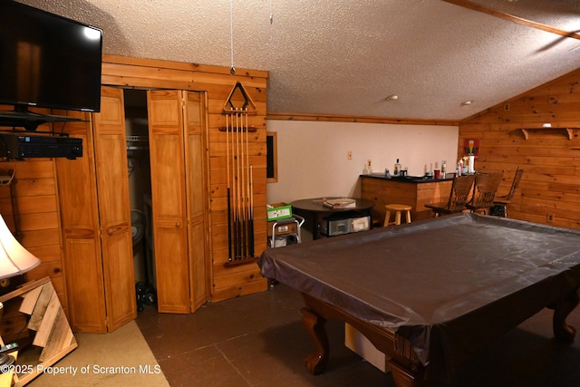 rec room featuring bar area, a textured ceiling, wooden walls, and billiards