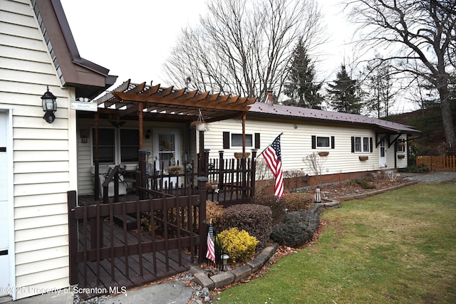 rear view of property with a pergola and a lawn