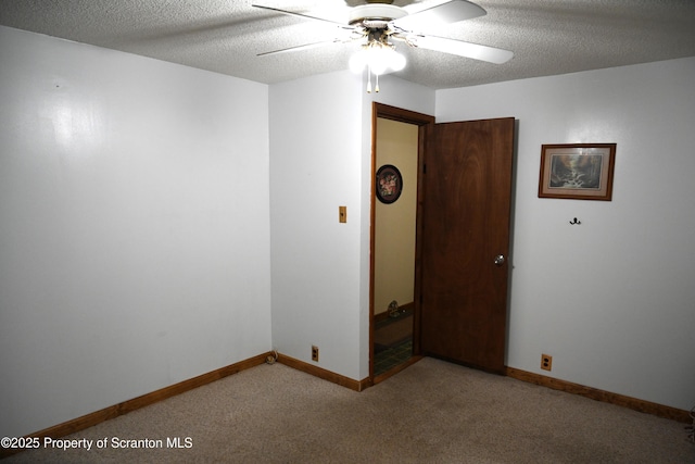 carpeted spare room featuring ceiling fan and a textured ceiling