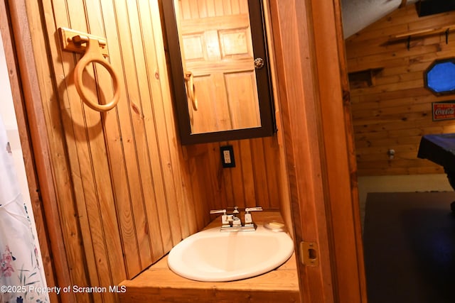 bathroom with wood walls and sink