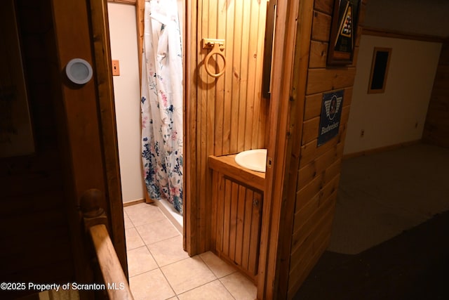 bathroom featuring tile patterned flooring, a shower with curtain, vanity, and wood walls