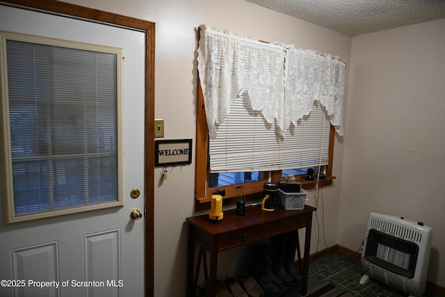 entryway with a textured ceiling and heating unit