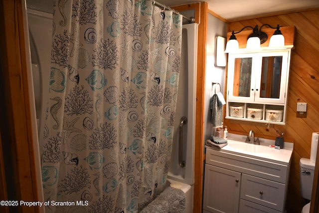 bathroom featuring vanity, wood walls, toilet, and walk in shower