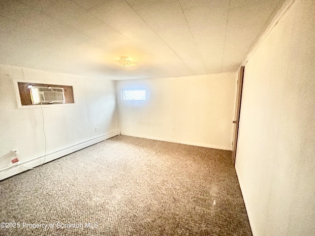 unfurnished room with a textured ceiling, carpet floors, a wall mounted AC, and a baseboard radiator