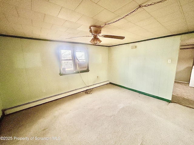 carpeted empty room with baseboard heating, a ceiling fan, and crown molding