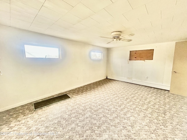 basement featuring carpet floors, ceiling fan, and baseboards