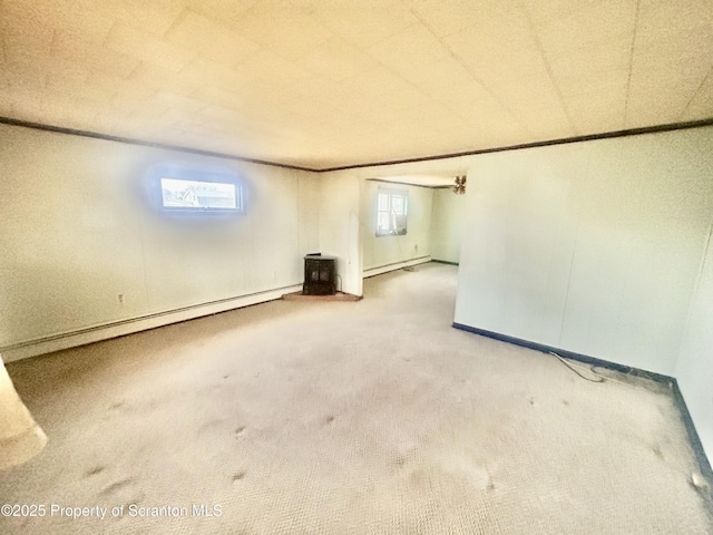 empty room featuring carpet, a baseboard radiator, and baseboards