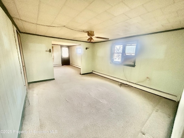 below grade area featuring baseboards, ceiling fan, baseboard heating, carpet floors, and a baseboard heating unit