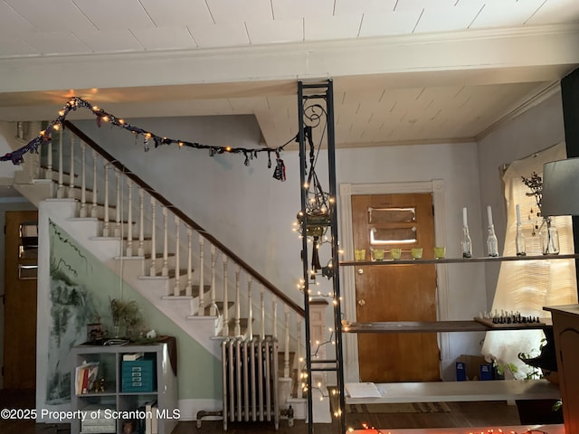 stairs with crown molding and radiator heating unit