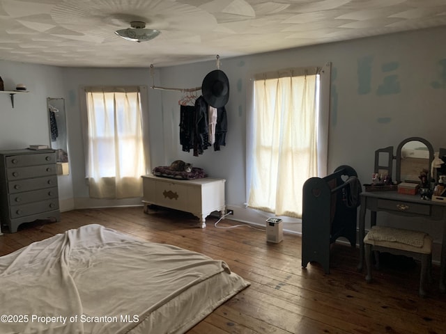 bedroom featuring hardwood / wood-style flooring and baseboards