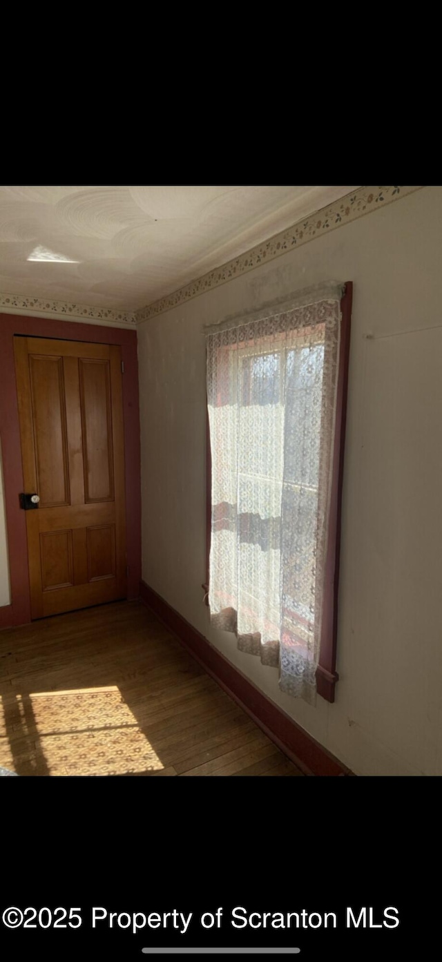 spare room featuring baseboards and light wood-style flooring