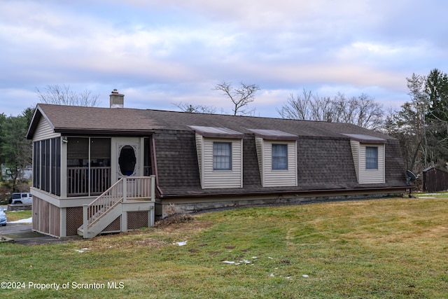 view of front of home featuring a front lawn and a sunroom