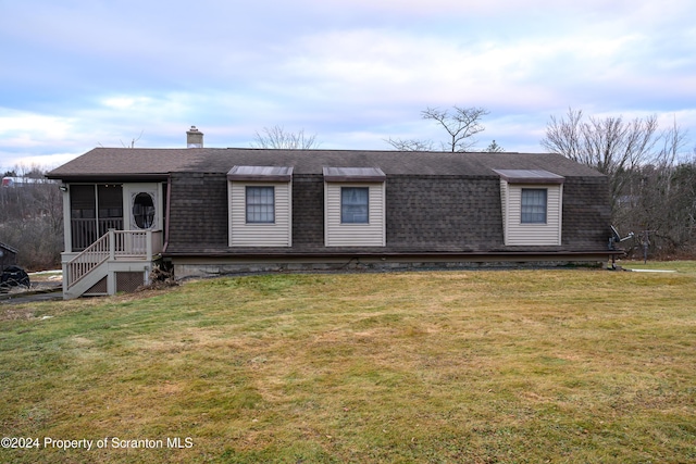 view of front facade featuring a sunroom and a front yard