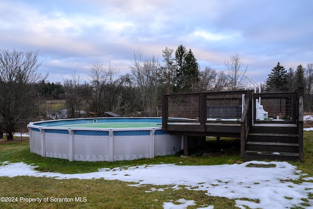 snow covered pool featuring a deck