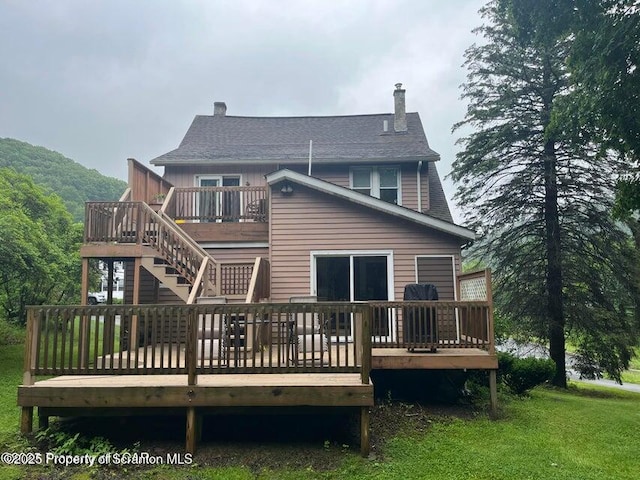 121 Burcher Ave, South Abington Twp, PA 18411 - rear view of property featuring a deck, a chimney, roof with shingles, and a lawn