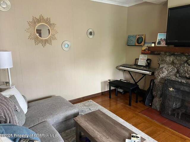 121 Burcher Ave, South Abington Twp, PA 18411 - living area featuring a stone fireplace, crown molding, baseboards, and wood finished floors
