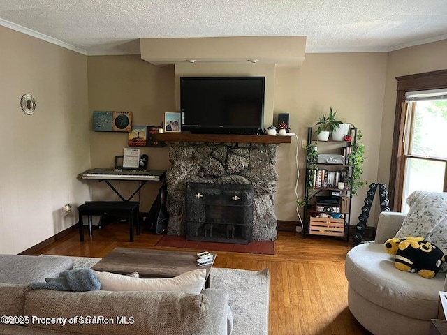 121 Burcher Ave, South Abington Twp, PA 18411 - living area featuring crown molding, wood finished floors, a textured ceiling, baseboards, and a stone fireplace