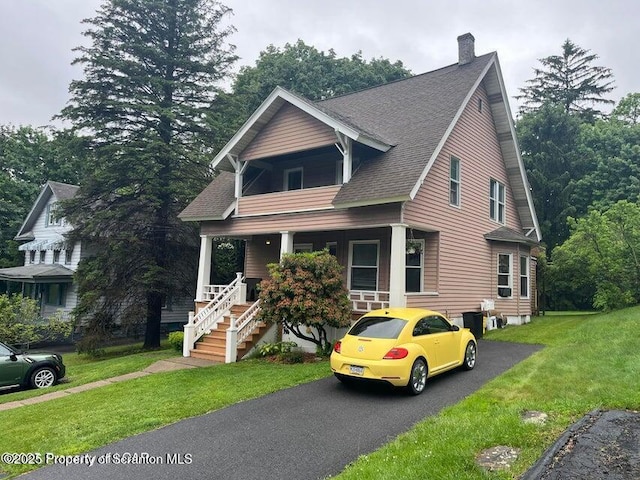 121 Burcher Ave, South Abington Twp, PA 18411 - view of front of house with covered porch, a chimney, a front lawn, and a shingled roof