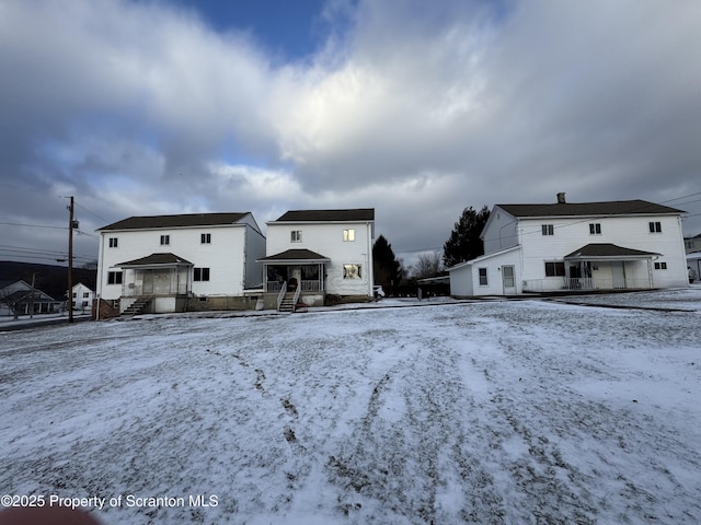 view of snow covered back of property