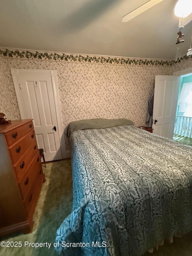 carpeted bedroom featuring ceiling fan and wallpapered walls