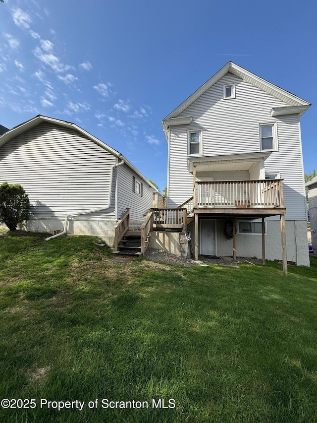 back of property featuring a yard, a deck, and stairway