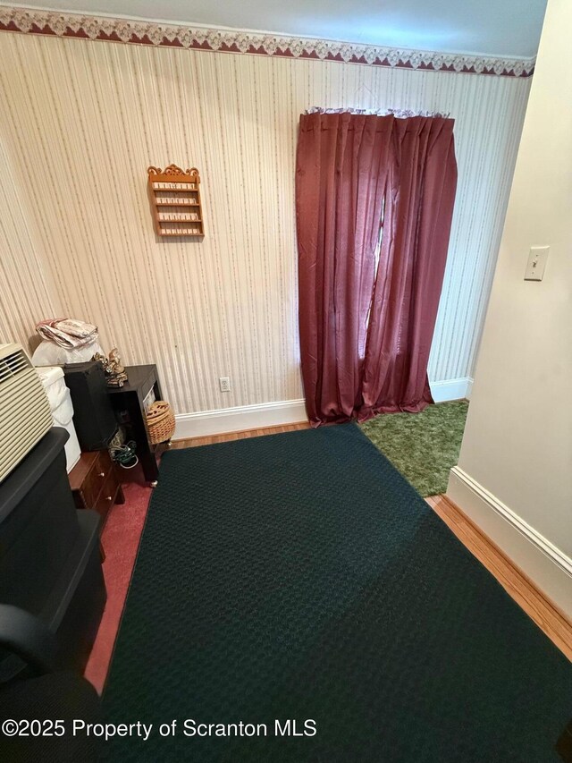 interior space featuring wallpapered walls and baseboards