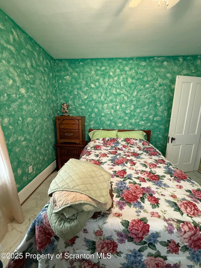 bedroom featuring wallpapered walls, baseboards, and marble finish floor