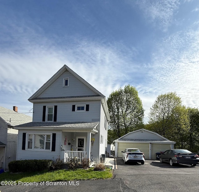 view of front of home featuring an outbuilding, covered porch, and a detached garage