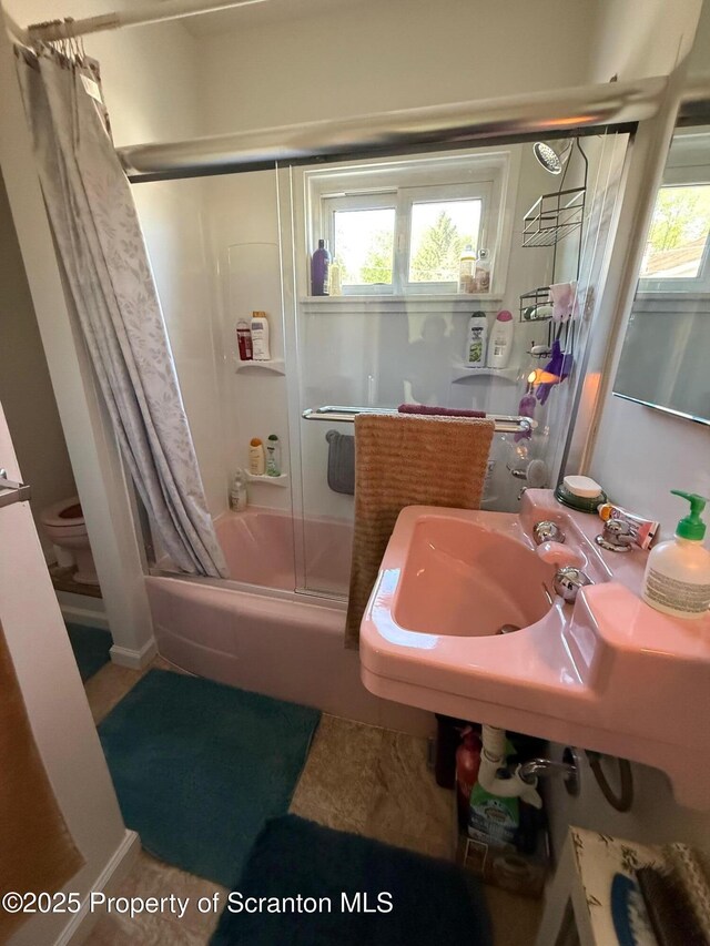 full bath featuring toilet, enclosed tub / shower combo, and a healthy amount of sunlight