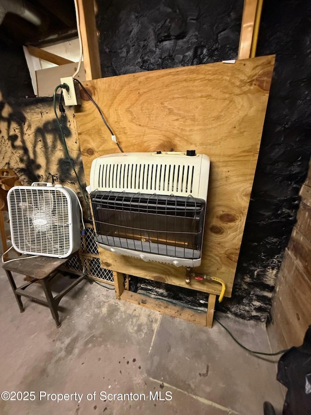 interior details with heating unit and unfinished concrete floors