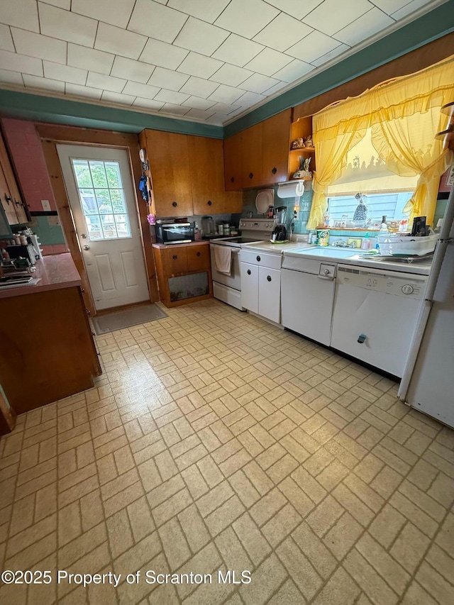 kitchen featuring white appliances, white cabinets, brick patterned floor, and a toaster