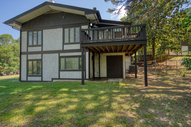 rear view of property with a deck and a lawn