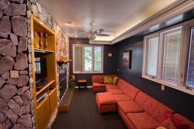 home theater featuring a fireplace, dark colored carpet, and ceiling fan