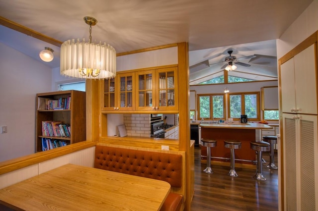 dining room with vaulted ceiling, dark hardwood / wood-style flooring, and ceiling fan with notable chandelier